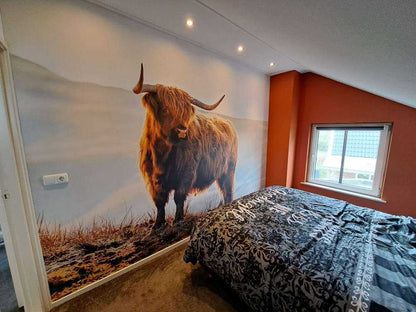 Fotobehang - Schotse hooglander op een heuvel